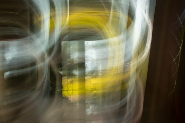 Kuva: abstrakti kuva, jossa kaartuvia valkoisia ja keltaisia viivoja ruskeallapohjalla